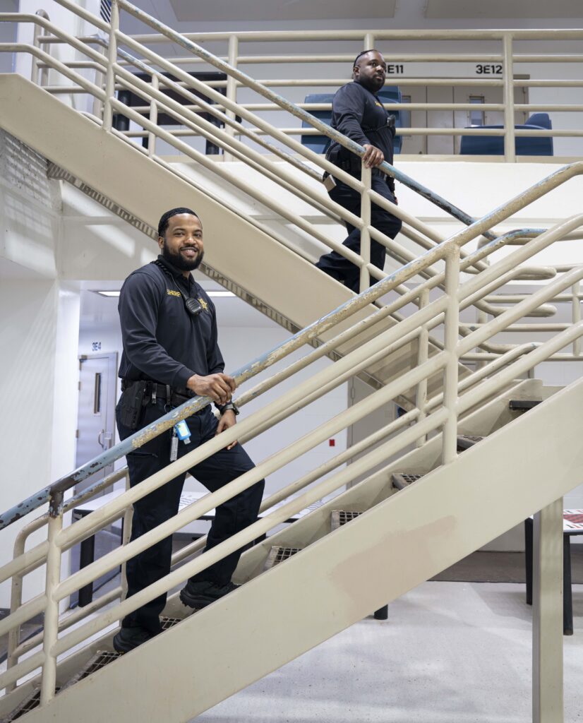 two deputies on different flights of stairs inside a jail