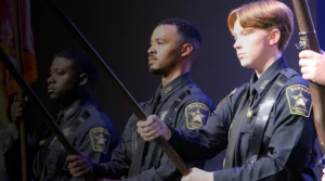 Three deputies holding flags as part of honor guard